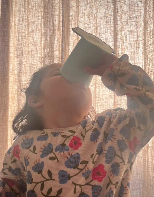 Peuter leert drinken uit een open beker zonder tuit