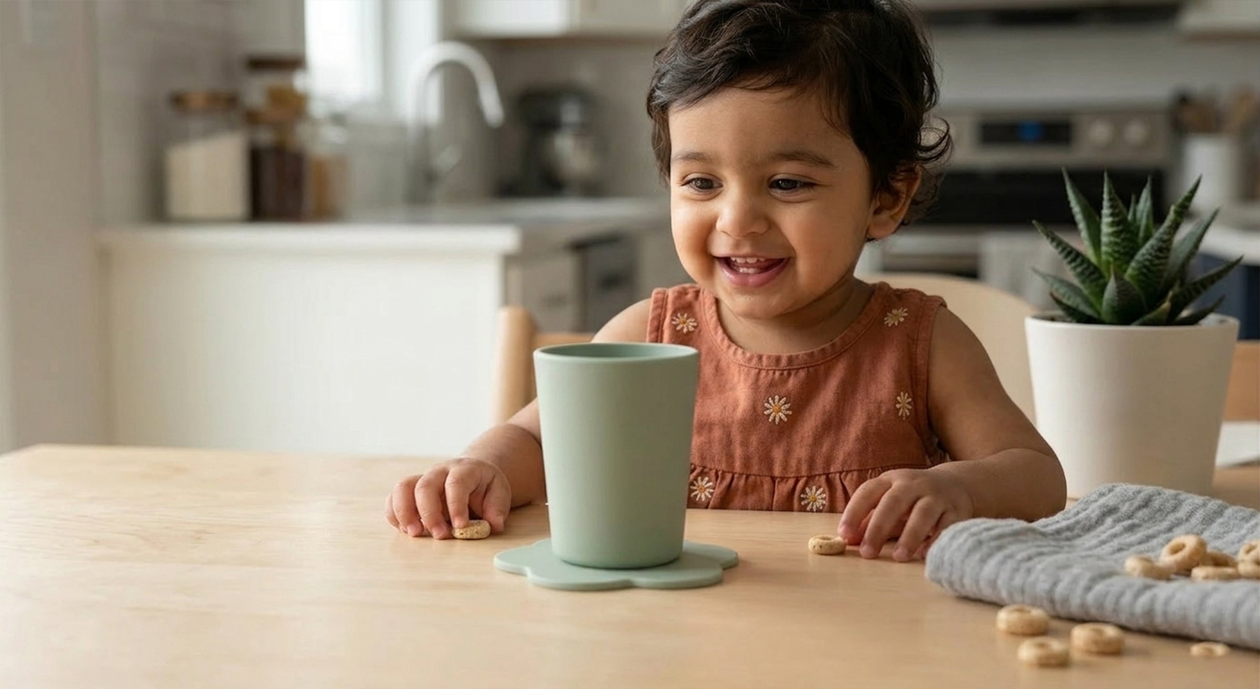 peuter leert zelfstandig drinken met STEDDI kinderbeker op tafel
